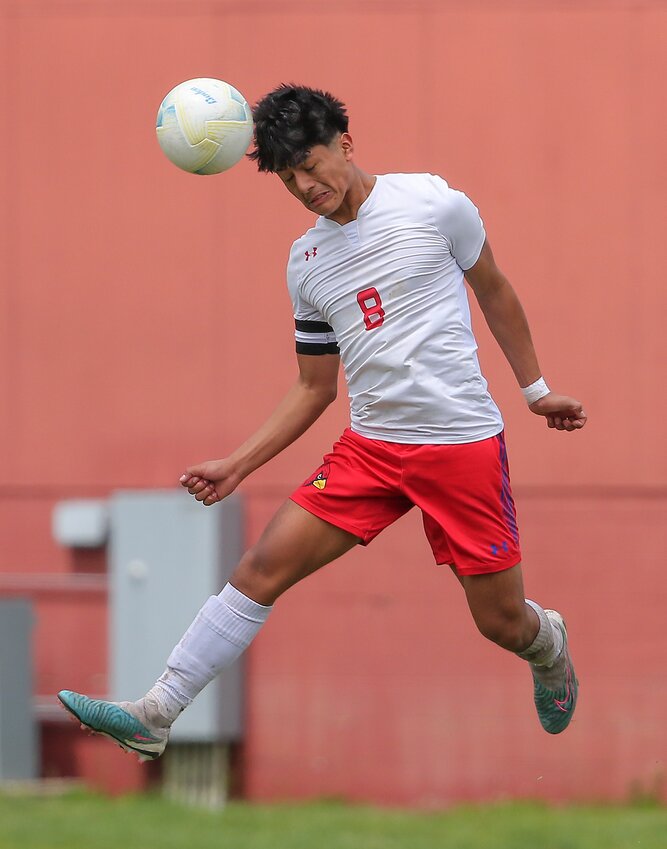 Crete's Emanuel Chanchavac Matias heads the the ball away during the Cardinals' 3-1 district final victory over Omaha Roncalli May 4.