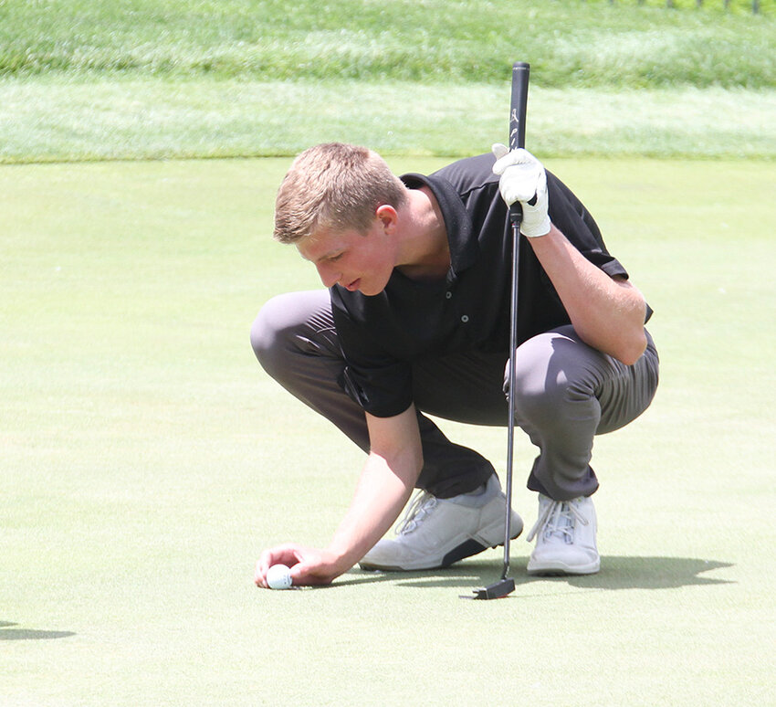 Carter Milton of EMF places his ball on the green during the Class C state golf tournament May 22.