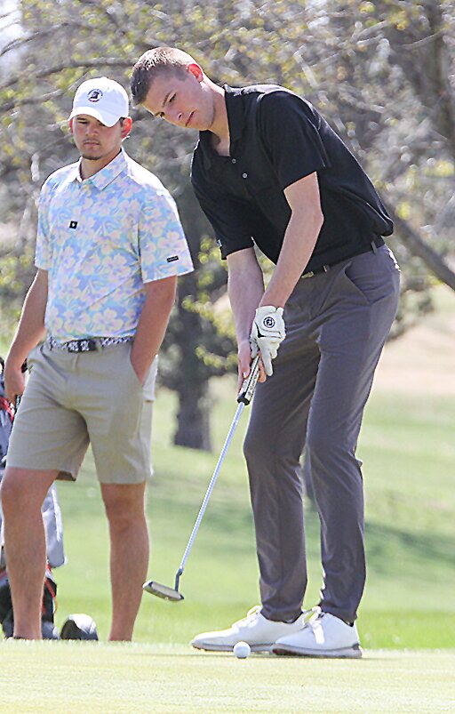 Carter Milton of EMF taps his putt across the green during a tournament in Friend April 9.