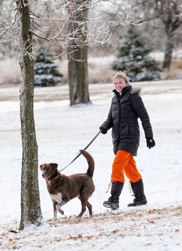 Valerie Johnson and &quot;Boone&quot; enjoy a quick walk in a Wilber park last Thursday after Wednesday's storm left snow and ice on much of the area. Photo by Doug Carroll.