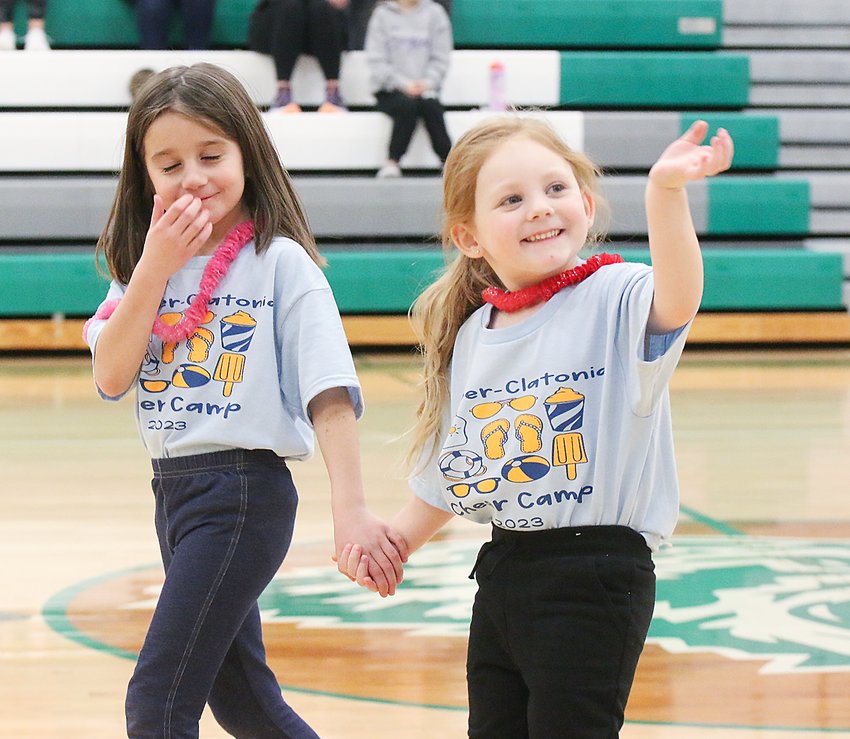 Kaydence Shore and Haizleigh Duncan wave to their fans and take their places to perform Jan. 27. The girls were part of the Wilber-Clatonia cheer camp Jan. 27 and performed at halftime of the girls' basketball game.