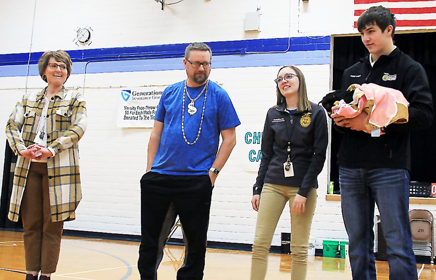 Leesa Bartu/FS  The audience at a pep rally hosted by Exeter-Milligan/Friend FFA on March 1 voted who would get to kiss a goat between, from left, Principal Laura Kroll, history teacher Jordan Marr and ag/welding teacher Miranda Hornung. Chase Svehla held the baby goat for the lucky(?) winner.