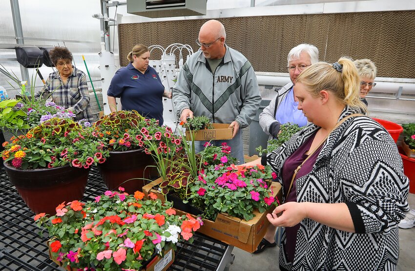 Patrons at Friend High School's plant sale wait in the check out line with some of the flowers they picked out.