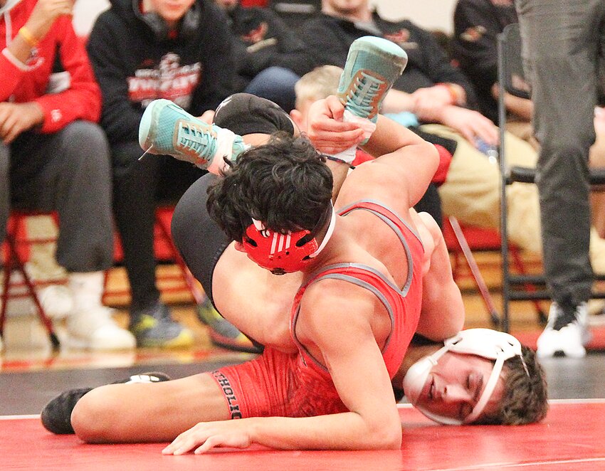 Grant Eschiti of Wilber-Clatonia, right, works to turn Yair Santiago  of Norfolk Catholic in their district championship match Feb. 10.
