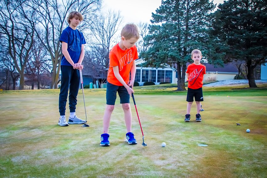 College Heights Country Club opened the course on Feb. 21 due to unseasonably nice weather on Feb. 21. Eighth grader Keaton Draeger, 14, took Elliot Rische (8) and Paxton Rische (5) up to the course after school. Here Elliott practices his putting..