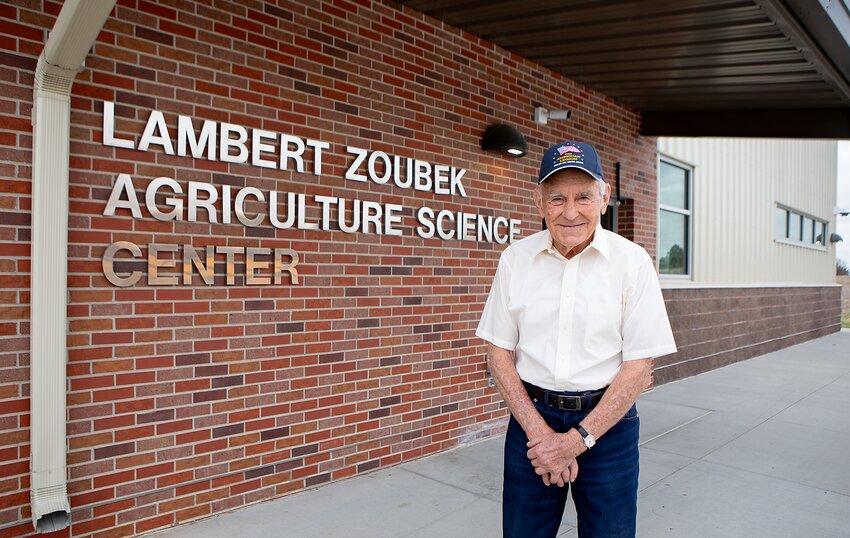 Lambert Zoubek poses next to agriculture science building that he paid to have built at Wilber-Clatonia High school.