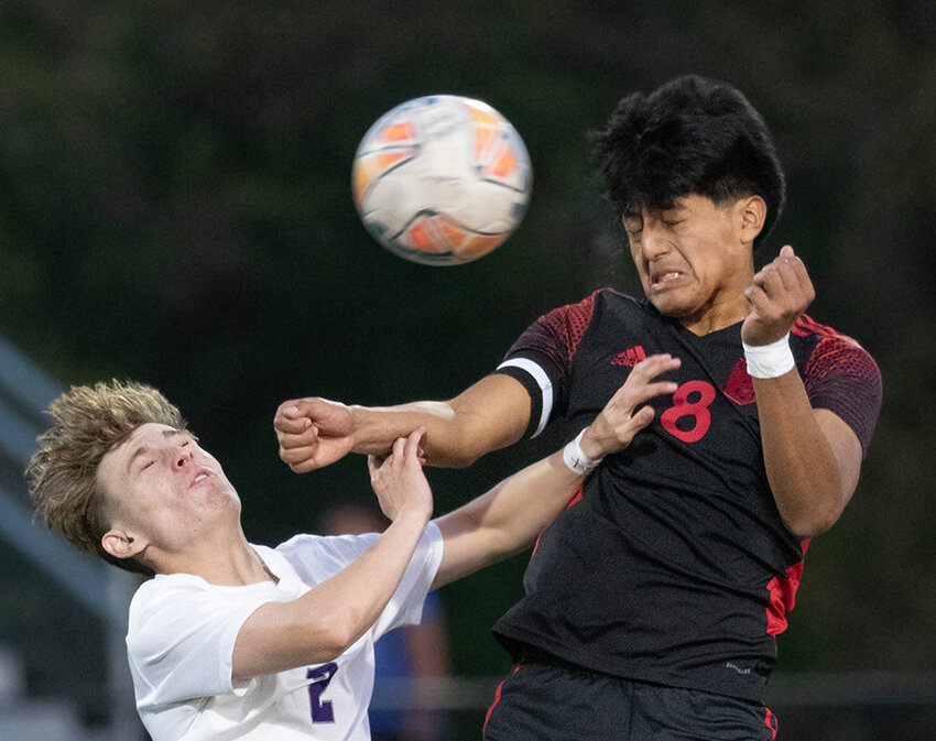 Crete senior Emanuel Chanchavac Matias heads the ball away from a Lincoln Northwest defender during the Cardinal's 4-0 Subdistrict B-5 victory April 30.