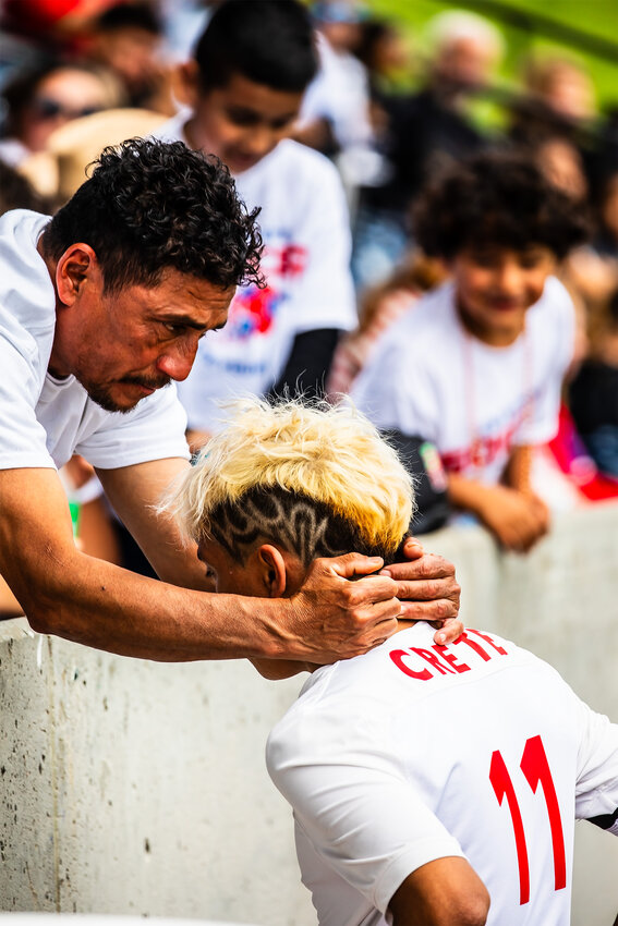 At the half Enzo Giron is encouraged and prayed over by a member of the crowd when Crete boys soccer took on Omaha Skutt at the state soccer tournament May 9. The Crete boys fell to Omaha Skutt Catholic, losing 3-0.