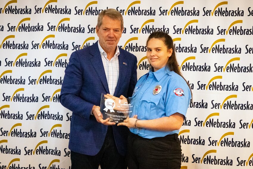 Governor Jim Pillen presents Cyndralynn Meredith, a Crete High School student and member of the Southeast Nebraska Medical Reserve Corps and the Southeast Nebraska Community Emergency Response Team, with the Disaster Volunteer of the Year Award at the Serve Nebraska Step Forward Awards on Oct. 4 in Omaha. Meredith was recognized for her exceptional commitment to volunteerism in preparation for and during times of disaster.