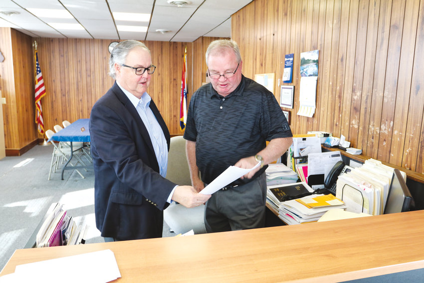 Interim City Administrator Jeff Hancock (left) and Fayette Mayor Greg Stidgham wrestled through stacks and stacks of paperwork Wednesday at City Hall.