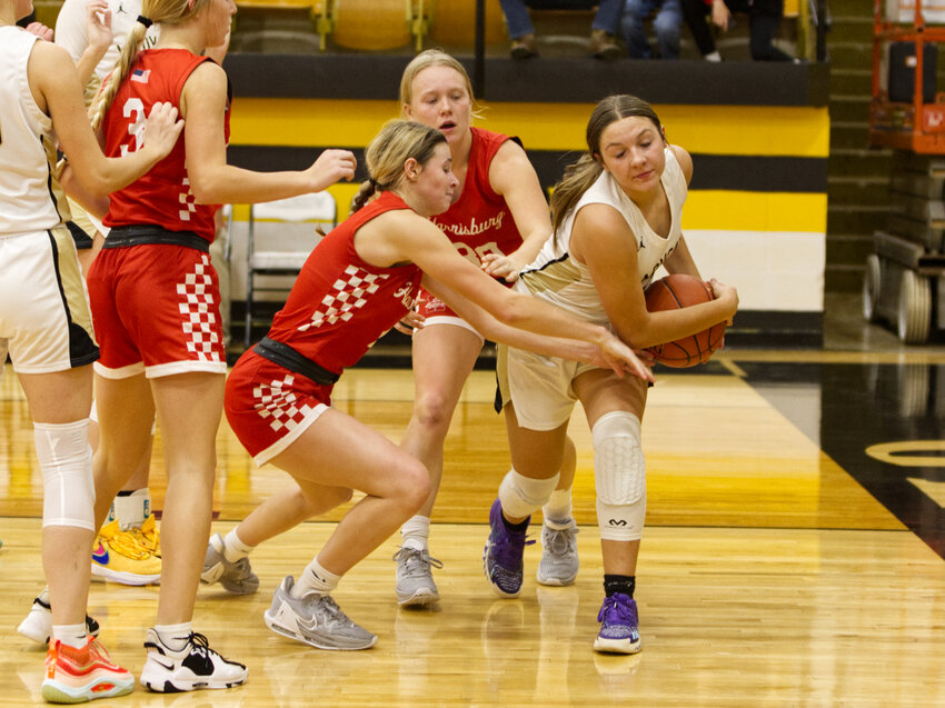 Harrisburg seniors Abby Rosson and Emma Fischer fight for a rebound with Cairo's Avery Brumley.