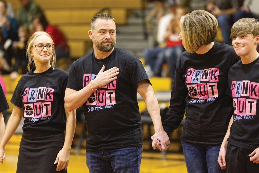 Steven John shows his appreciation as he is honored between the high school varsity games Friday night. Members of the John family, left to right: daughter Cayle, Steven John, wife Dana, and stepson Morgen.