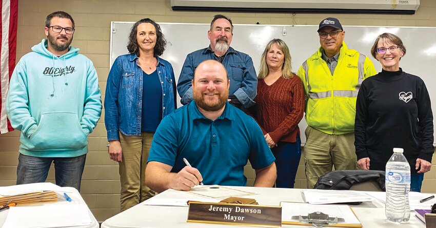 As one of his final acts in office, Fayette Mayor Jeremy Dawson signed an Arbor Day proclamation during the city council’s regular meeting on March 26. Mayor Dawson did not seek a second term and will turn over the gavel to returning mayor Greg Stidham on April 9, which will be the council’s first meeting following the April 2 municipal elections. 
Seated, Mayor Dawson signs the proclamation along with past and present members of Fayette’s Tree board. Standing, left to right: Gene Gerlt, Dana Morris, Brian McMillan, Denise Haskamp, Ben Roberts, and Bekki Galloway.