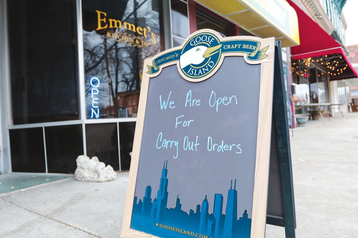 A sign of the time in front of Emmet’s Kitchen & Tap advertises the restaurant is still open for take-out and delivery orders.