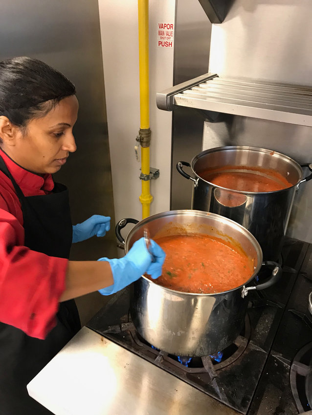 This picture shows  Reshma making sauce.