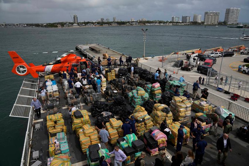 Journalists, politicians, and federal officials stand along with members of the Coast Guard and other law enforcement agencies, as they view more than one billion dollars worth of seized cocaine and marijuana aboard Coast Guard Cutter James at Port Everglades, Thursday, Feb. 17, 2022, in Fort Lauderdale, Fla. (Rebecca Blackwell/AP)