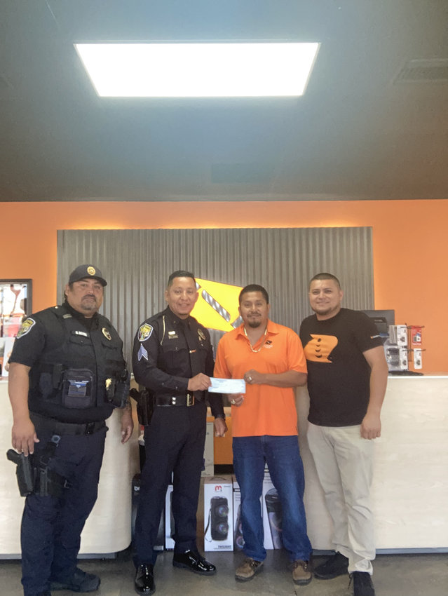 Owners of the Boost stores, Valentin Bautista and Ceferino Espinoza, donated a check to Okeechobee City Police to help cover cost of Honor Guard uniforms.
