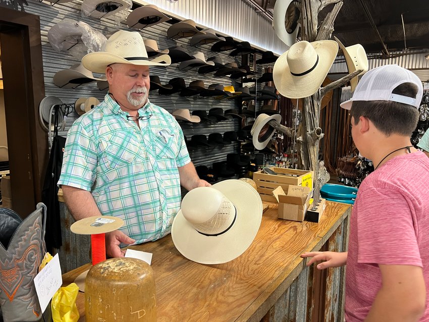 OKEECHOBEE -- Jay Crews (left) discussed the desired hat design with the customer. [Photo by Katrina Elsken/Lake Okeechobee News]