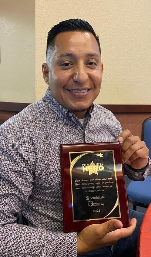 Detective Sgt. Aurelio Almazan displays Community Hero award.