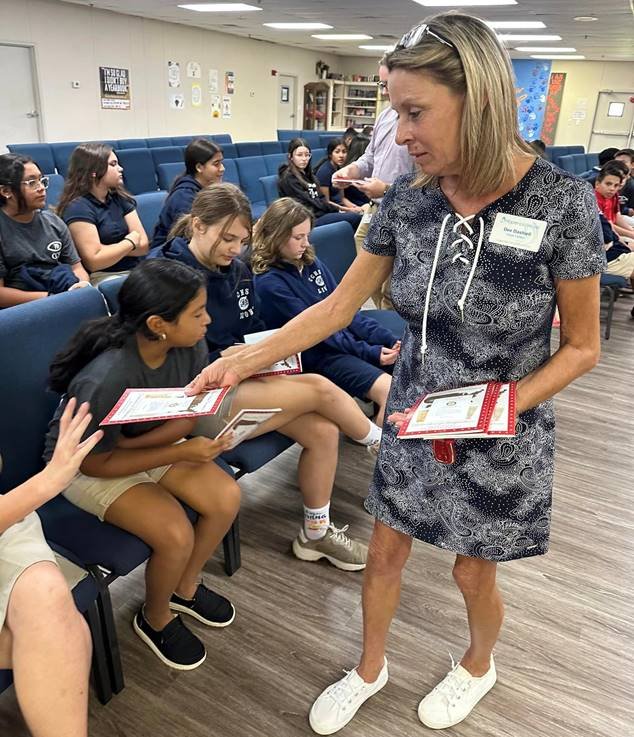 Rotarian Dee Dashiell provides students with constitution books courtesy of the Clewiston Rotary.