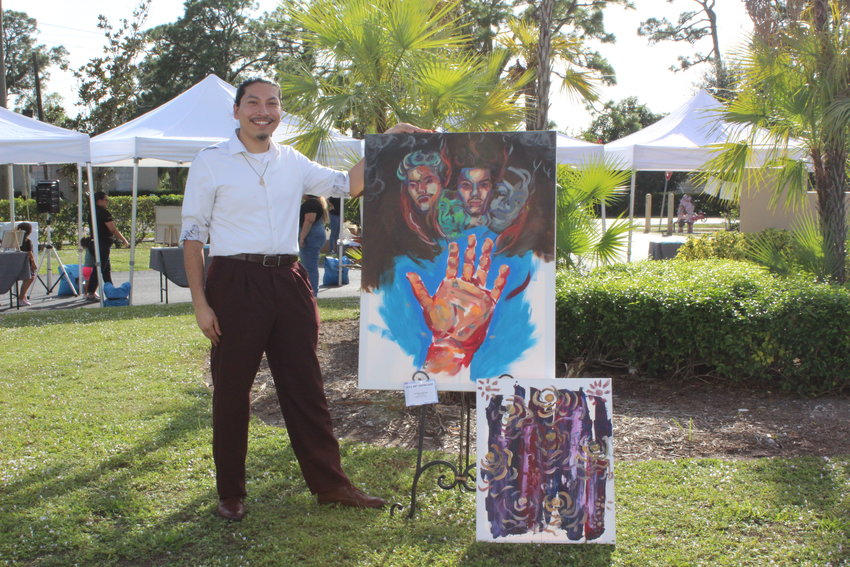 Immokalee Foundation’s Art Education Specialist Jonathan Martinez with two of his paintings.