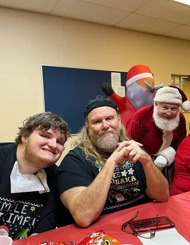 Anthony Golden (center) and his son Hunter had a great time at the annual Special Athletes of Okeechobee Christmas party. Santa even photobombed their picture during the party. Hohoho