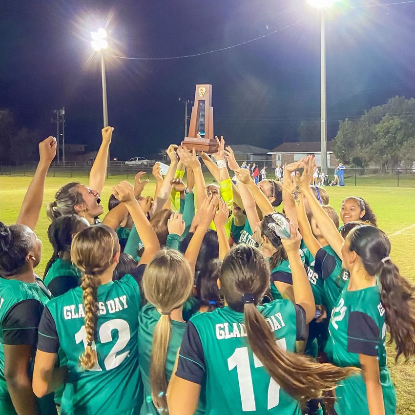 The Lady Gators celebrate with the championship trophy. [Photo courtesy Glades Day School/Lake Okeechobee News]