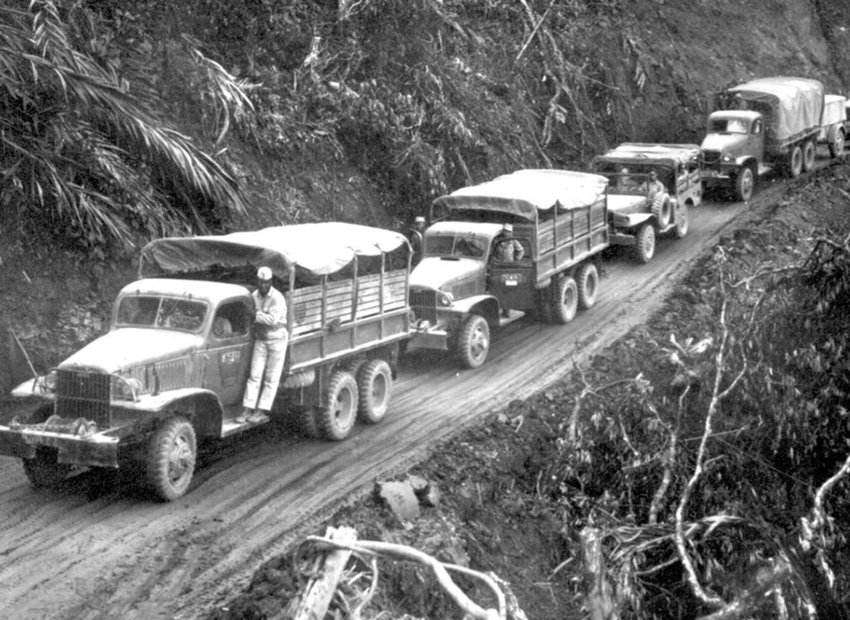 “U.S.-built Army trucks wind along the side of the mountain over the Ledo supply road now open from India into Burma…” [Photo courtesy National Archives]