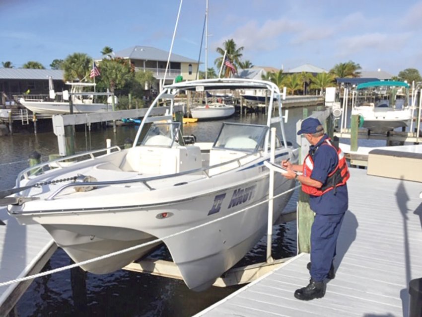 Coast Guard Auxiliarist Ccnducts dockside Vessel Safety Check. [Photo courtesy US Coast Guard]