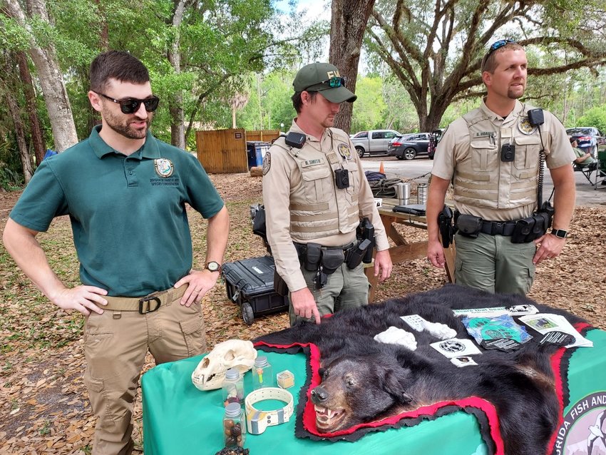 FWC biologist and law enforcement with black bear education exhibit. [Courtesy photo]