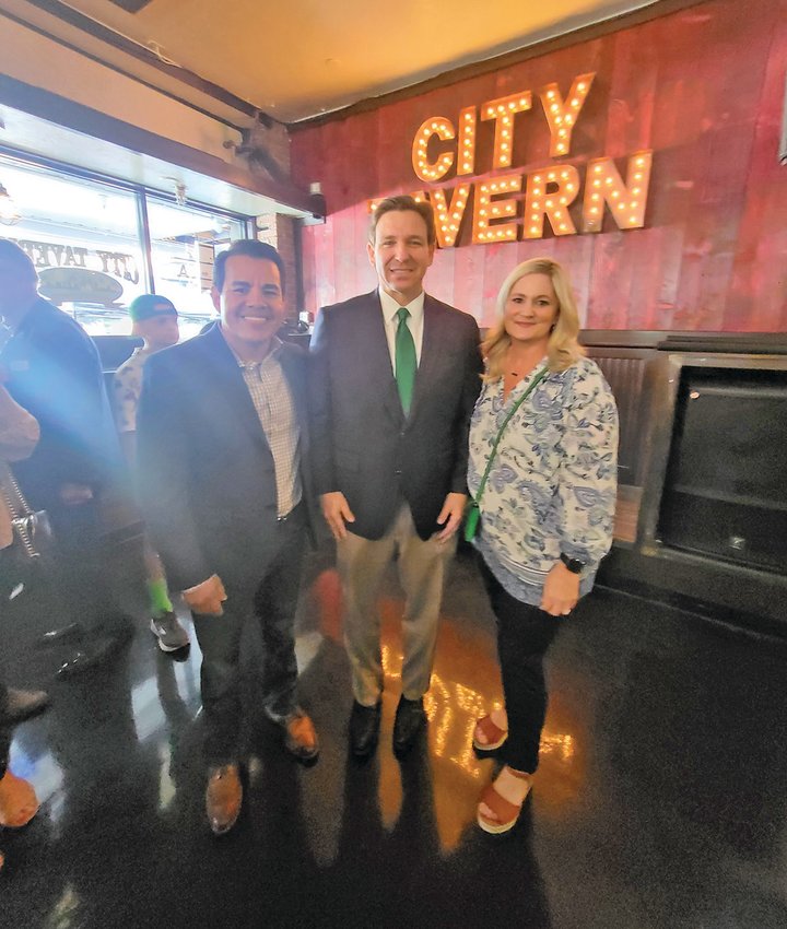 Governor DeSantis (middle) with City Commissioner Hugo Vargas (left) and his wife Natasha (right)
