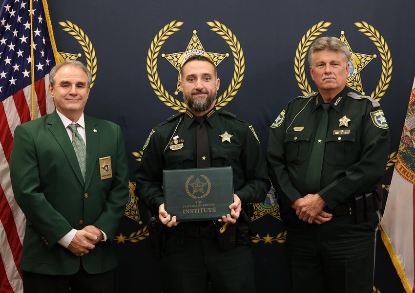 The Commanders Academy has become recognized as the premier course of executive study for mid to upper-level criminal justice leaders.
 Lieutenant John Rhoden(center) displays his certificate of graduation.