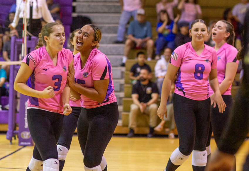 The Lady Brahmans celebrate after winning the third set.