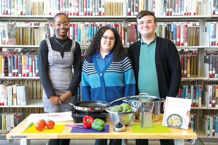 IRSC student Jezyah Mann with IRSC Pruitt Campus staff Evelyn Soto and William Campos (left to right) as they display one of the kitchen kits available through the Health Hub. The hub is Indian River State College Libraries’ newest lending library to put kitchen and gardening tools in the hands of local residents and College students. (Photo by James Crocco/IRSC)