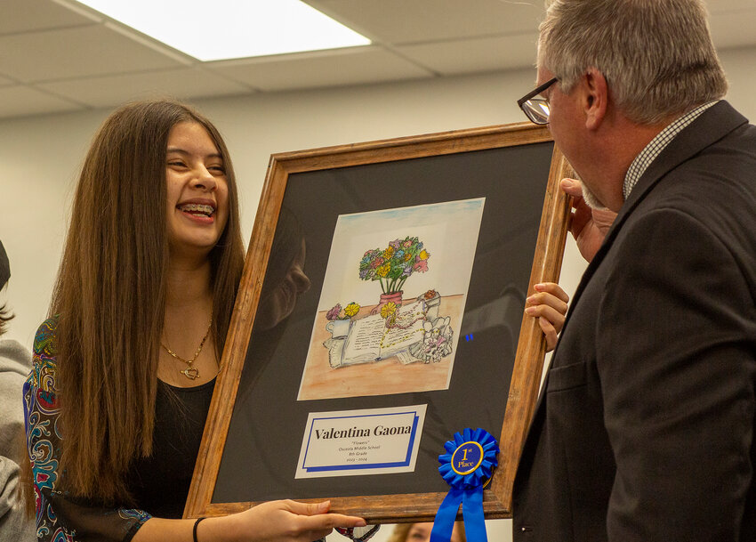 Valentina Gaona talking with superintendent Ken Kenworthy about her art titled "Flowers".