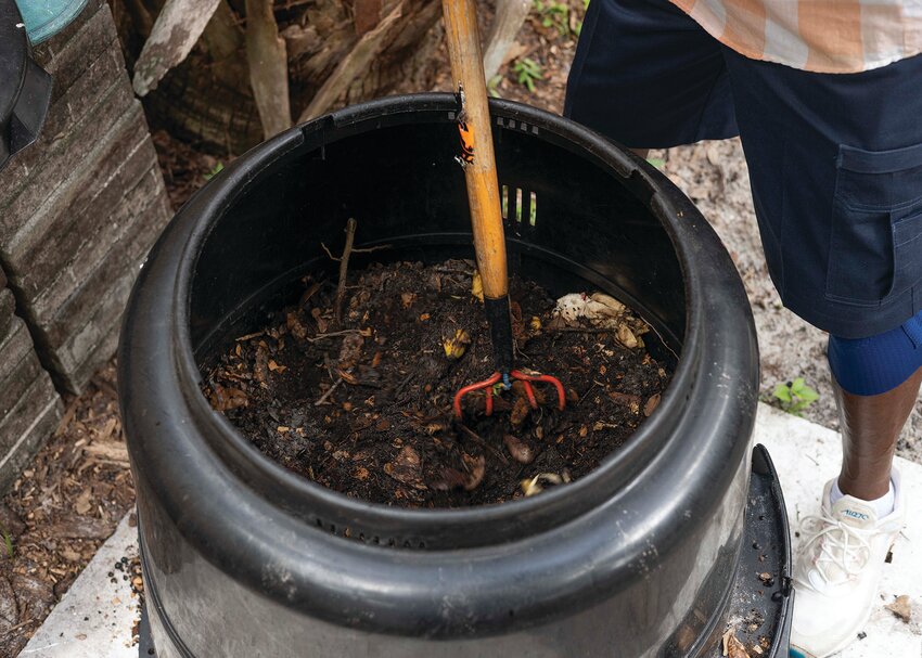 Composting basics require just a few steps that include stirring the contents in preparation for use in gardening