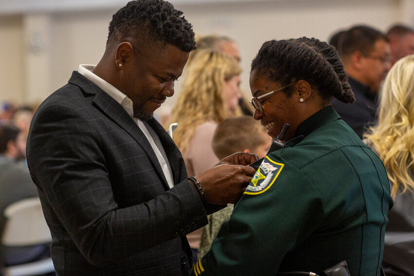 Family members helped pin badges to deputies after being sworn in. [Photo by Richard Marion]