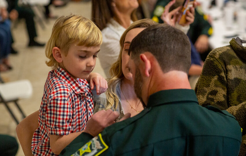 Family members helped pin badges to deputies after they were sworn in. [Photo by Richard Marion]