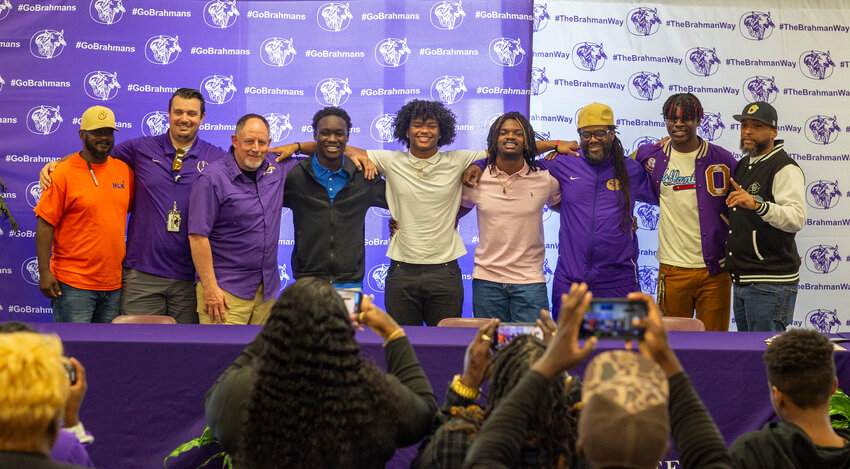 Members of the Brahman coaching staff pose for pictures with the four varsity players who signed to Palm Beach Elite. [Photo by Richaard Marion]