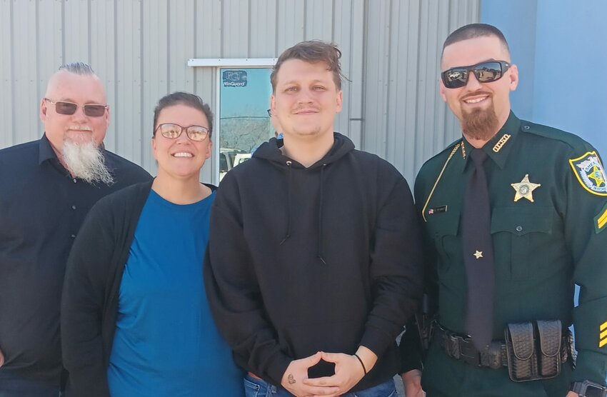 Kain Sarros is pictured with his parents, Kenny and Kim and the deputy who, while off duty, showed up at the scene and saved Kain's life.