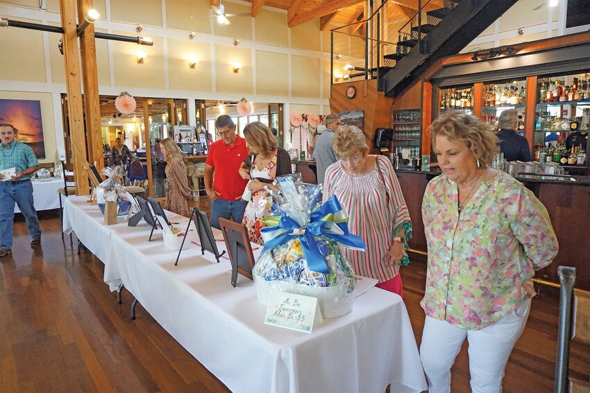 Attendees of the 2023 Swing into Spring event checking out the silent auction items.