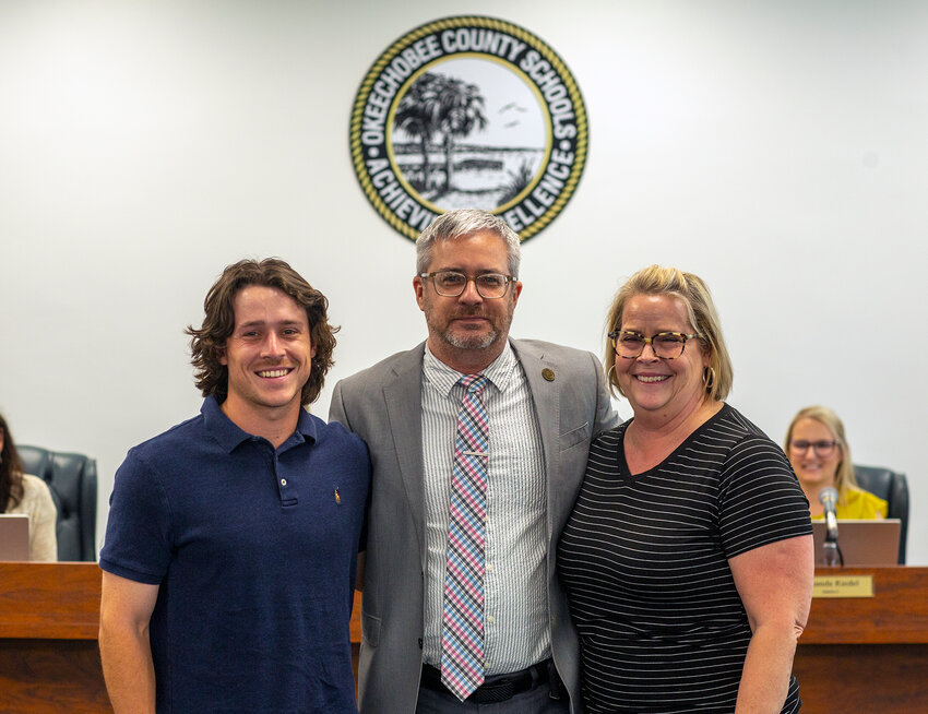Dylan Tedders with his son and wife after being chosen as the Okeechobee School District's new superintendent. (Photo by Richard Marion/Lake Okeechobee News)