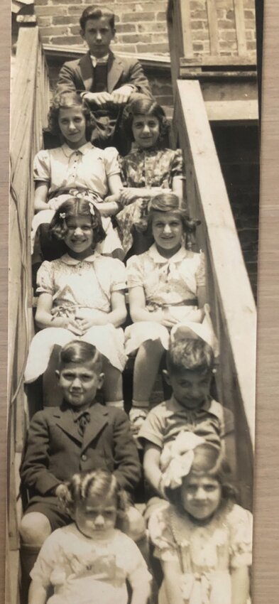 Mary West (second step from top, left) is pictured with seven of her nine siblings plus one of her cousins..[Photo courtesy Mary West]