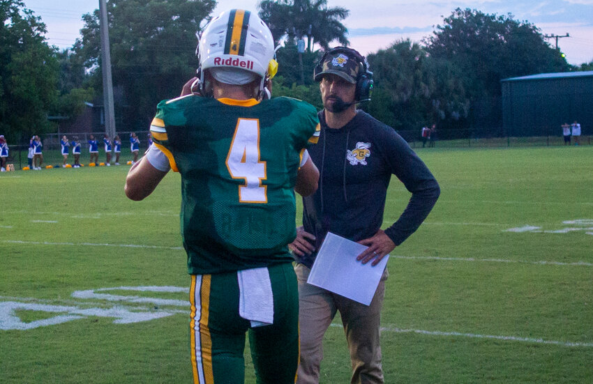 Glades Day coach Zach Threlkeld speaks to Logan Wilkins during a timeout. [Photo by Richard Marion/Lake Okeechobee News]