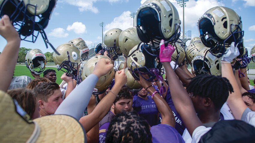 The Brahmans raise their helmets after a practice. [Photo by Richard Marion/Lake Okeechobee News]