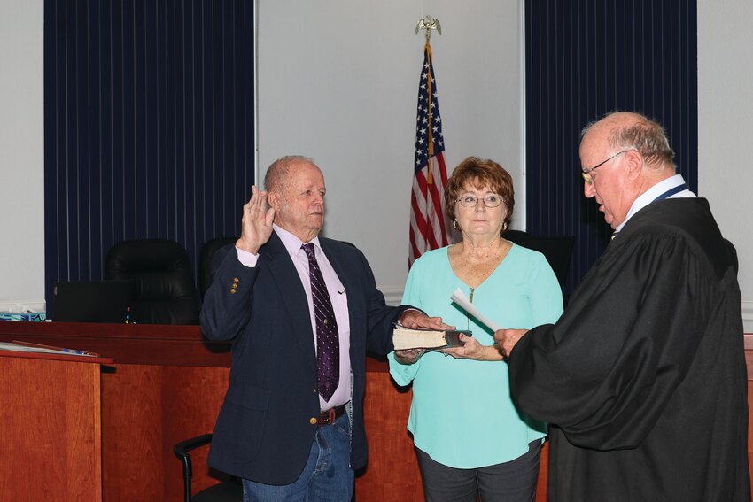 Councilman Noel Chandler is sworn in as a city council member on Monday, Jan. 6. He is pictured with Judge William Wallace. Chandler's wife Louise stands by his side..[Photo by Sandra Pearce]