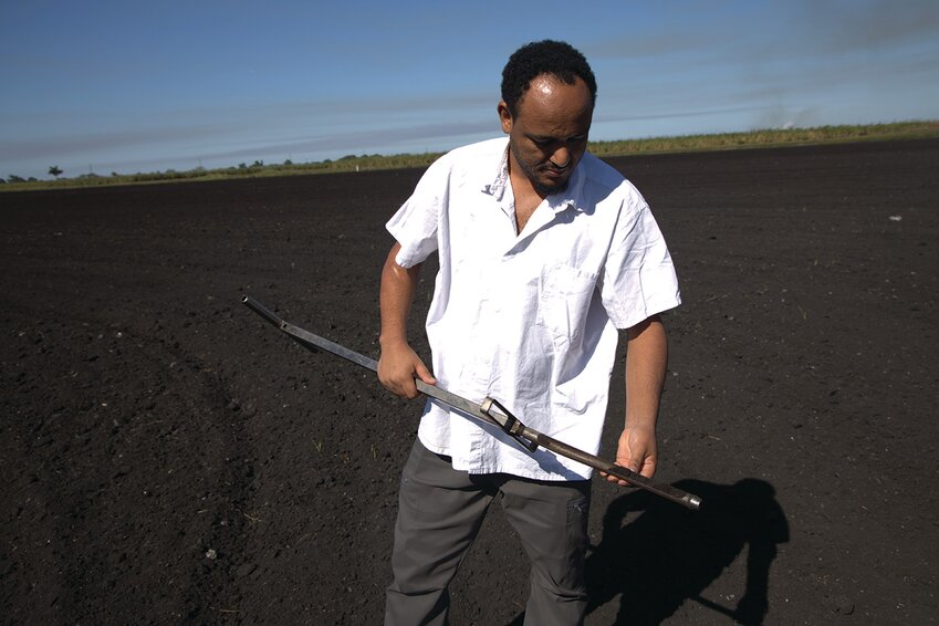 Niguss Solomon Hailegnaw, UF/IFAS EREC assistant professor and Everglades Soil Testing Lab director, examines muck soil in the Everglades Agricultural Area.