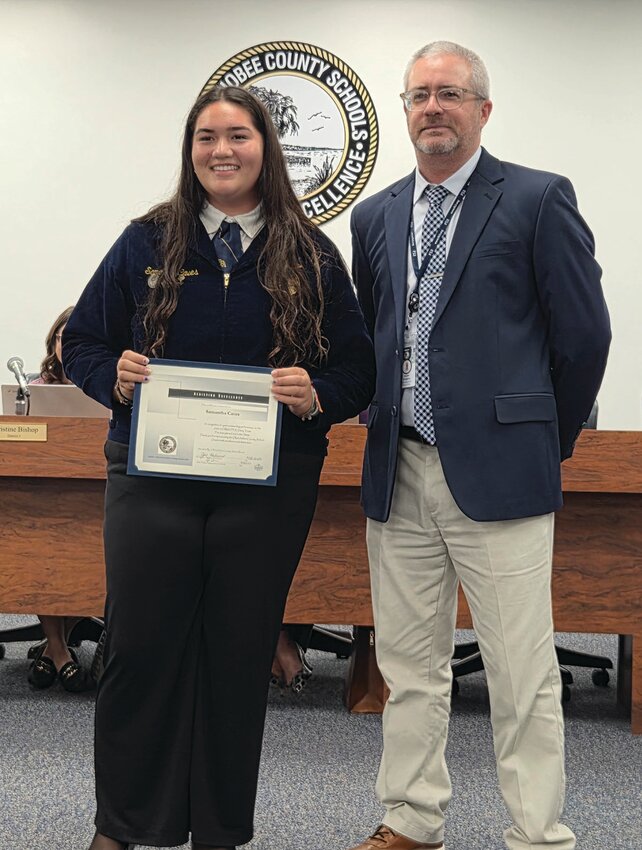 OKEECHOBEE — YMS FFA Dairy Judging Team member Samantha Caves (left) with Superintendent Dylan Tedders (right).