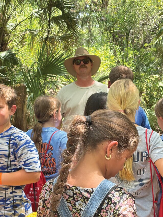 Florida Forest Service Forester Clark Ryals lead enthusiastic students on the “Call of the Wild Nature Walk” through the LaBelle Rotary Nature Park. [Photo by Margaret England]