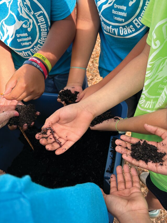 Students learned about earthworm development and had an opportunity to dig in the soil, then capture, and hold an earthworm. [Photo courtesy Margaret England]